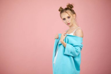 mutlu genç kız model pembe bir arka plan bahar giysileri studio poz. Gençler, parlak renkler moda. Turkuaz ceket