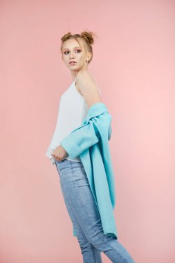 mutlu genç kız model pembe bir arka plan bahar giysileri studio poz. Gençler, parlak renkler moda. Turkuaz ceket