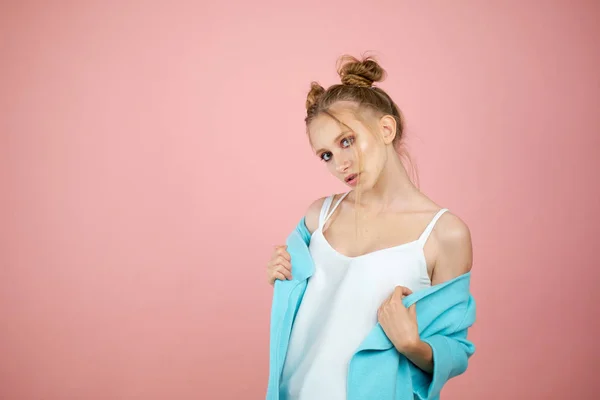 Счастливая молодая девушка модель позирует в студии на розовом фоне в весенней одежде. мода для подростков, яркие цвета. бирюзовый плащ — стоковое фото