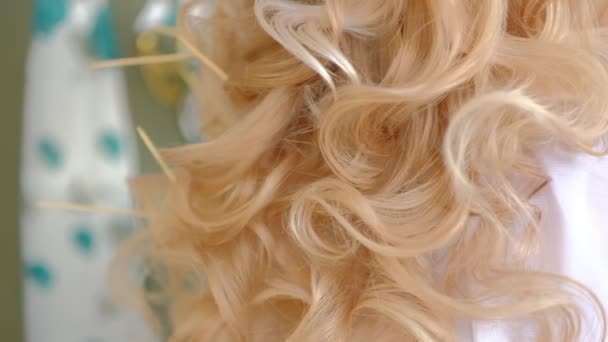 Жіноча рука з яскравим манікюром, що проходить через довге хвилясте світле волосся — стокове відео