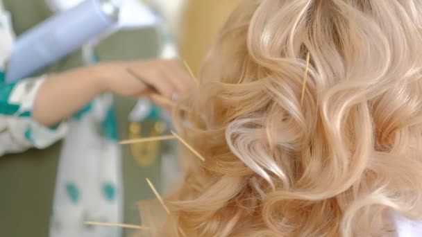 Eine Frauenhand mit heller Maniküre, die durch lange wellige blonde Haare läuft — Stockvideo