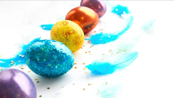 Square of easter eggs on a white background. scattered blue feathers. banner for text — Stock Photo, Image