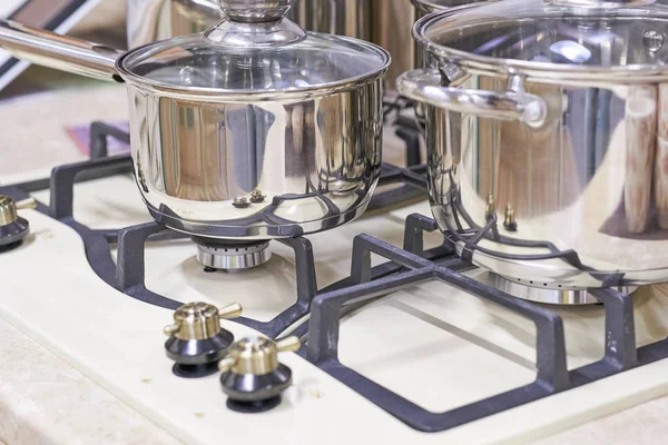 A nova frigideira no prato de cozinha espelho no interior branco. As verduras frescas estão perto de uma panela de ato de fritar em uma mesa de pedra branca. Janela grande no fundo . — Fotografia de Stock