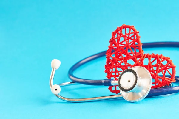 Stethoscoop en rood hart op blauwe achtergrond, medische zorgconcept, personeel medische verzekering — Stockfoto