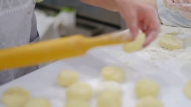 Mutlu gülümsedi büyükanne ve torunu bir hamuruna birlikte yoğurma yakın. Yaşlı bir kadın ve küçük çocuk yavaş hareket makarna veya pizza birlikte hazırlanıyor.