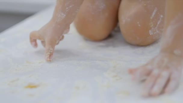 Grappige jongen spelen in de keuken met bloem. lastige kind op hom. ondeugende kinderen — Stockvideo