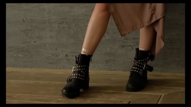 Dívka v Mensu černé boty a večerní šaty stojí u zdi se sklenkou vína — Stock video