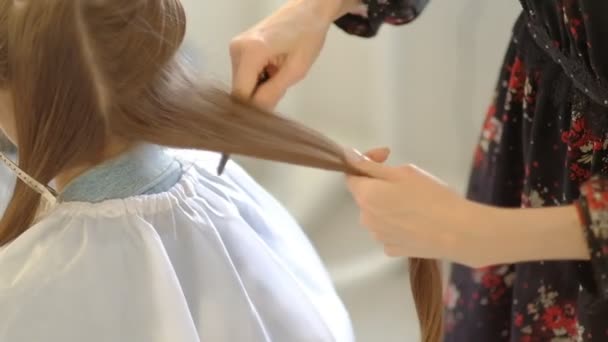 Master making hairstyle a girl at the beauty salon. slow motion — Stock Video