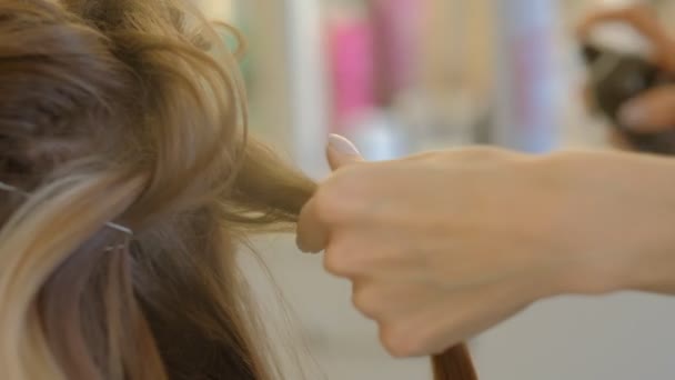 Mestre fazendo penteado uma menina no salão de beleza. câmara lenta — Vídeo de Stock