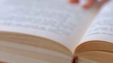 Elleriyle sayfaları çeviren kitabın yakın çekim. kitap sayfalarını açın. yavaş çekim