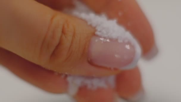 Hand des Kochs wirft weiße Salzkristalle in Zeitlupe in Großaufnahme. Weibliche Hand schüttet Salz. — Stockvideo