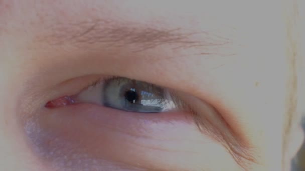 Slow Motion macro: man met glanzende blauwe ogen die naar de verte kijken. Reflecterende blauwe mannelijke oog observeren omgeving in lichte kamer. — Stockvideo