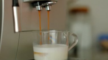Otomatik kahve makinesi cam bir fincan kapuçino veya latte dökme. yavaş çekim