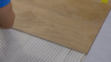 Bir adam yere çimento üstüne bir kiremit yerleştirir. Kiremit bir kesme meşe boyama vardır