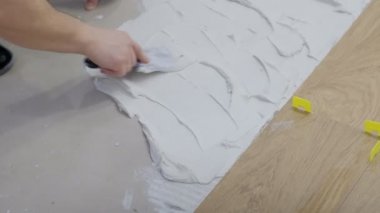 Şantiye de zemine fayans döşenen profesyonel işçi close-up Builder yere beton koyar.