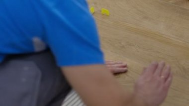 Bir adam yere çimento üstüne bir kiremit yerleştirir. Kiremit bir kesme meşe boyama vardır