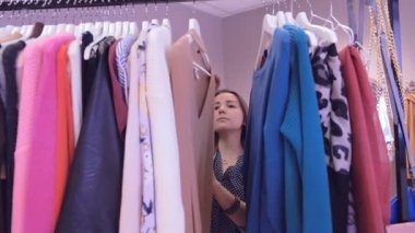 Kendini bulma yeni elbiseler içinde pahalı bir butik bir büyüleyici kadın portresi. O Etiketler okuma ve seçme.