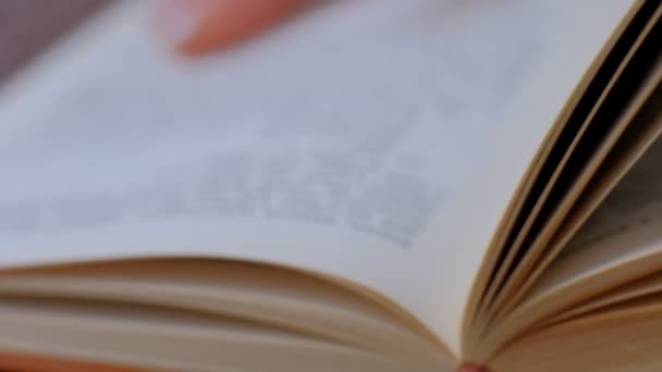 Close-up de livro com as mãos lançando através de páginas. páginas abertas do livro. câmara lenta — Vídeo de Stock