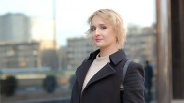 sarışın bayan sokak karşı kamera için siyah şapka ile poz