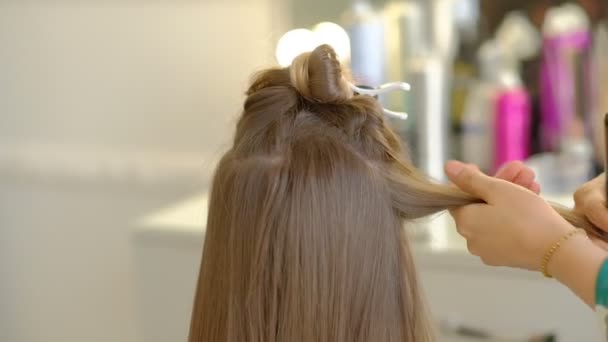 Mestre fazendo penteado uma menina no salão de beleza. câmara lenta — Vídeo de Stock