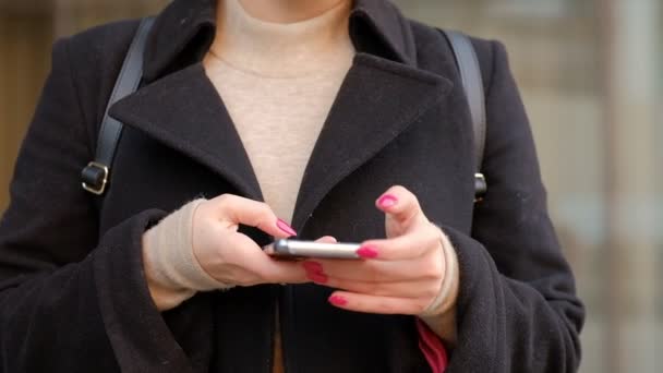 Mujer en una calle de la ciudad usando un teléfono móvil — Vídeos de Stock