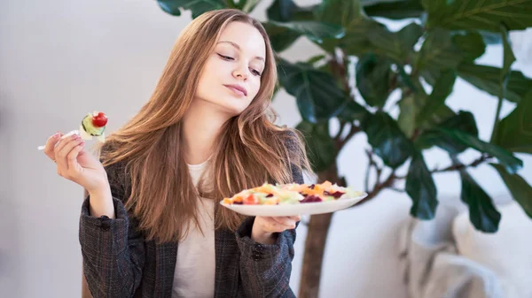 Woman in office eating salad at working place. Concept of lunch at work and eating healthy food. healthy eating concept. business woman in a jacket having lunch at the office — 스톡 사진