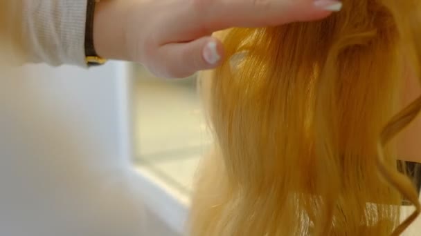 Dziewczyna Student Fryzjer robi fryzurę na manekinie głowę z długimi blond włosy w lekkim salonie fryzjerskim — Wideo stockowe