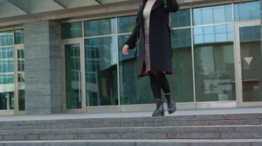 sırt çantası ile sarışın kız sokakta şapka koyarak yürüyor