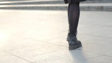 sırt çantası ile sarışın kız sokakta şapka koyarak yürüyor