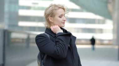 sarışın kız bulanık binaya karşı kamera için poz