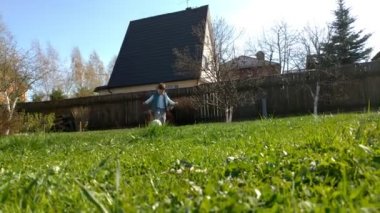 Mutlu bir çocuk mutlu bir futbol topu tekmeler ve yeşil çim bir alanda çalışır