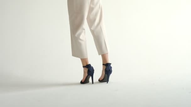 Отслеживание с низким сечением силуэта женских ног в туфлях на высоких каблуках ходьба деревянный паркет, замусоренный горизонт. замедленная съемка — стоковое видео