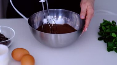 Cam kasede çırpılmış çikolatalı kek hamuru. Cam kaseyi yavaş çekimde çırpın. Kırbaçlamak için çırpın. Evde yemek, pasta, tatlı, krema.