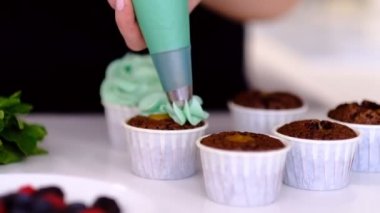 Kremalı kek dekorasyon. Pişirme torbası, parti için çok renkli kek pişirdiğini pudra kullanarak. Lezzetli kek, eve ekmek kavramı tereyağı krema koyarak kadının el atış