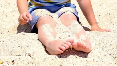 Yaz aylarında plajda kumla oynayan mutlu çocuk. Kumlarda oynayan çocuklar. Bu aktivite duyusal deneyim için iyidir. Yavaş Çekim