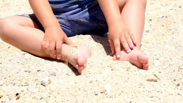 Ευτυχισμένο παιδί που παίζει με άμμο στην παραλία το καλοκαίρι. Παιδιά που παίζουν στην άμμο. Αυτή η δραστηριότητα είναι καλή για αισθητηριακή εμπειρία. Αργή κίνηση — Αρχείο Βίντεο