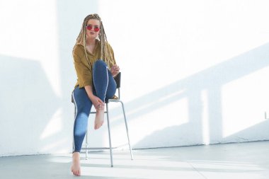 Beyaz arka plan üzerinde sandalyede oturan güzel artı boyutu kız Portresi