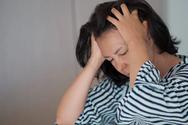 Kobieta o bólu głowy. ludzi, opieka zdrowotna, stres i koncepcja problemu-nieszczęśliwa Azjatycka młoda kobieta cierpiąca na bóle głowy w domu — Zdjęcie stockowe