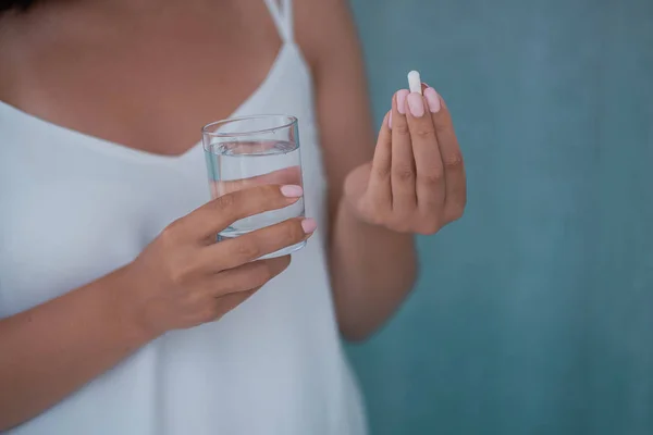 Sick female taking medicines, antidepressant, painkiller or antibiotic. Young lady drinking contraceptives. Pharmacy and healthcare concept