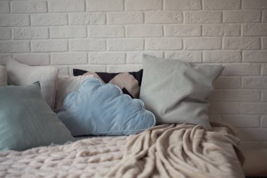 Büyük yatak ile modern oda iç. rahat çocuk oda parlak yumuşak renkler, yastıklar ve bir battaniye yatakta yatıyor.