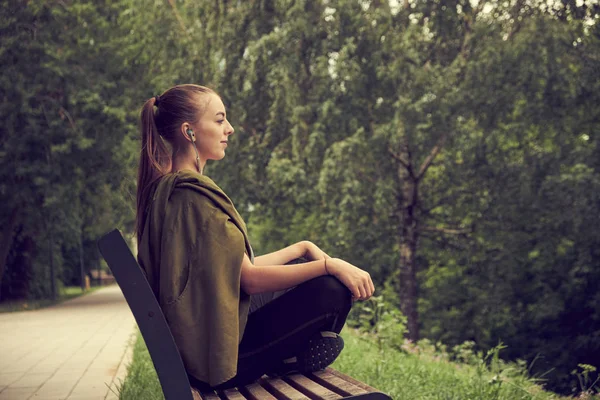 Молода кавказька жінка робить йогу в парку. Сидячи в положенні лотоса. — стокове фото