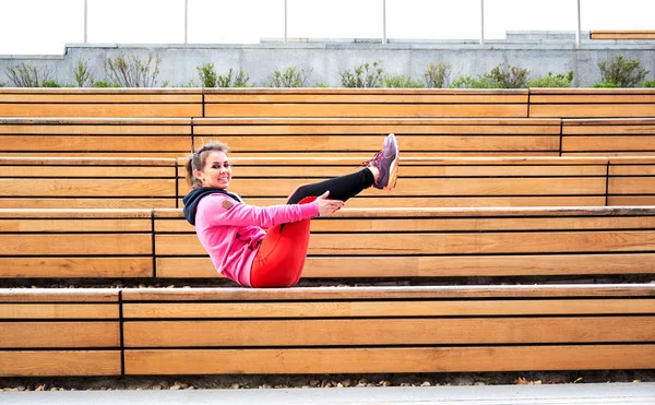 Yoga en la ciudad: sonriente hermosa joven deportista haciendo ejercicio en el día de verano en la calle — Foto de Stock