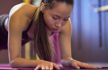 Egzersiz, spor. Spor salonundaki kadın. uzun saçlı genç Asyalı kız bir spor stüdyosunda bar gerçekleştirir