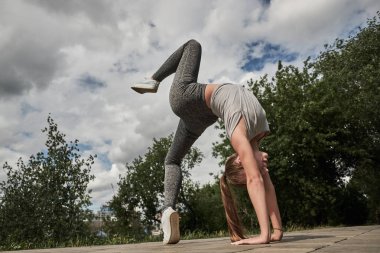 Genç sportif çekici kadın yoga, Wild Thing yapıyor, Flip-the-Dog egzersiz, Camatkarasana poz, egzersiz, spor giyim, siyah pantolon ve üst, kapalı tam uzunlukta giyiyor