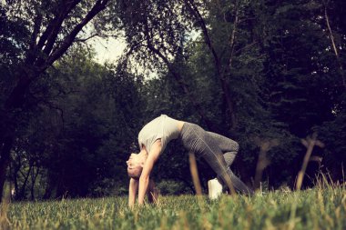 Genç sportif çekici kadın yoga, Wild Thing yapıyor, Flip-the-Dog egzersiz, Camatkarasana poz, egzersiz, spor giyim, siyah pantolon ve üst, kapalı tam uzunlukta giyiyor