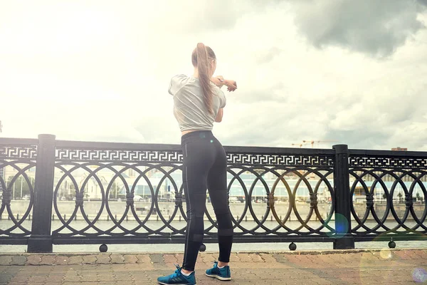 Retrato de mujer joven en forma y deportiva haciendo estiramiento en la ciudad. — Foto de Stock