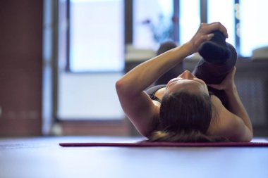 Moda sporu kıyafeti giyen güzel bir kız tavan arası spor salonunda spor yapıyor.