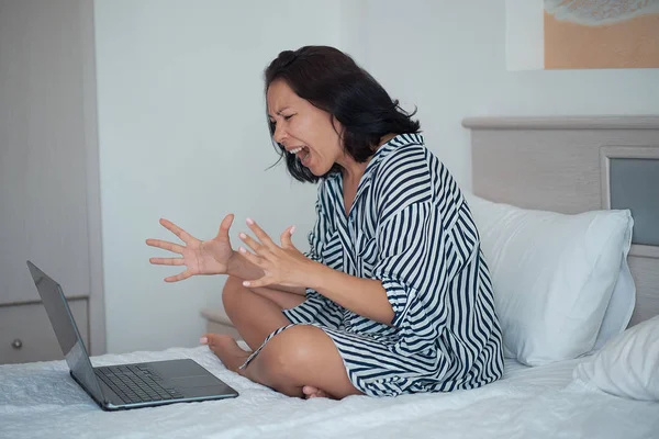 Evde bir dizüstü bilgisayar izlerken ofiste sürpriz kızgın kadın — Stok fotoğraf