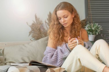 odasında kahve içme ve bir kitap veya dergi okuma genç kız