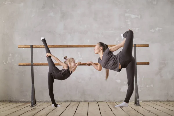 Ragazza graziosa ballerina in piedi su mani e stretching con insegnante in studio di danza — Foto Stock